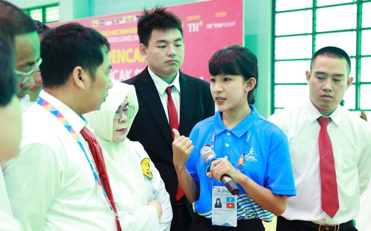 Quỳnh Anh (thứ hai, từ phải qua) phiên dịch cho trưởng đoàn cùng trọng tài tại một trận đấu chung kết pencak silat - Ảnh: ĐOÀN NHẠN Quỳnh Anh (thứ hai, từ phải qua) phiên dịch cho trưởng đoàn cùng trọng tài tại một trận đấu chung kết pencak silat - Ảnh: ĐOÀN NHẠN